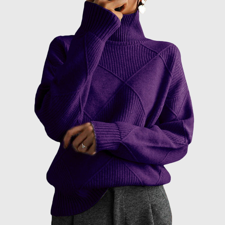 Model wearing deep purple oversized turtleneck sweater with arms crossed, front view