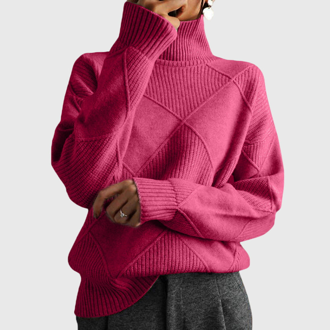 Model wearing pink oversized turtleneck sweater with arms crossed, front view