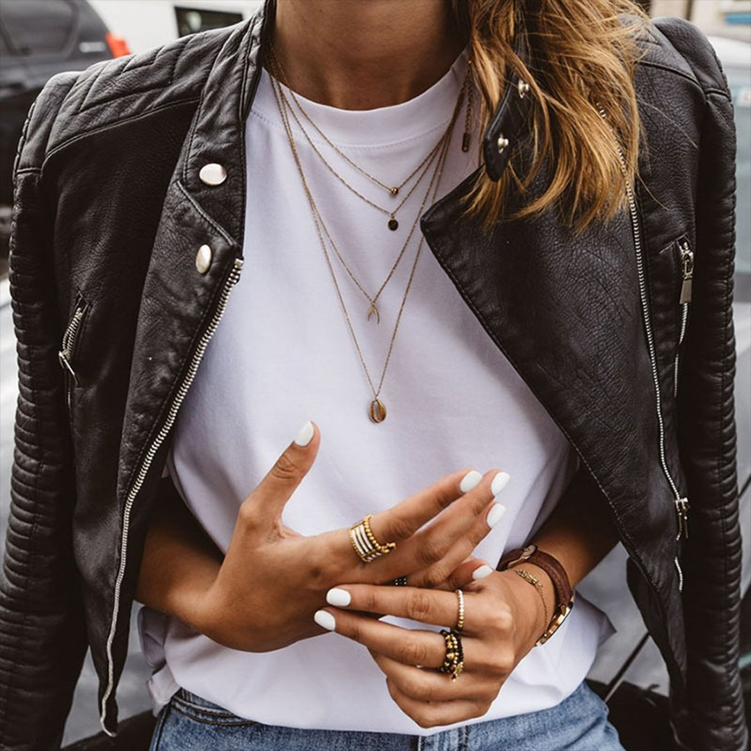 Close-up of biker jacket quilted collar and zip details with layered necklaces