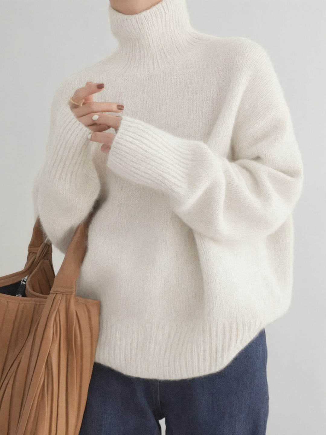 Elena oversized turtleneck sweater in cream, front view with tote bag