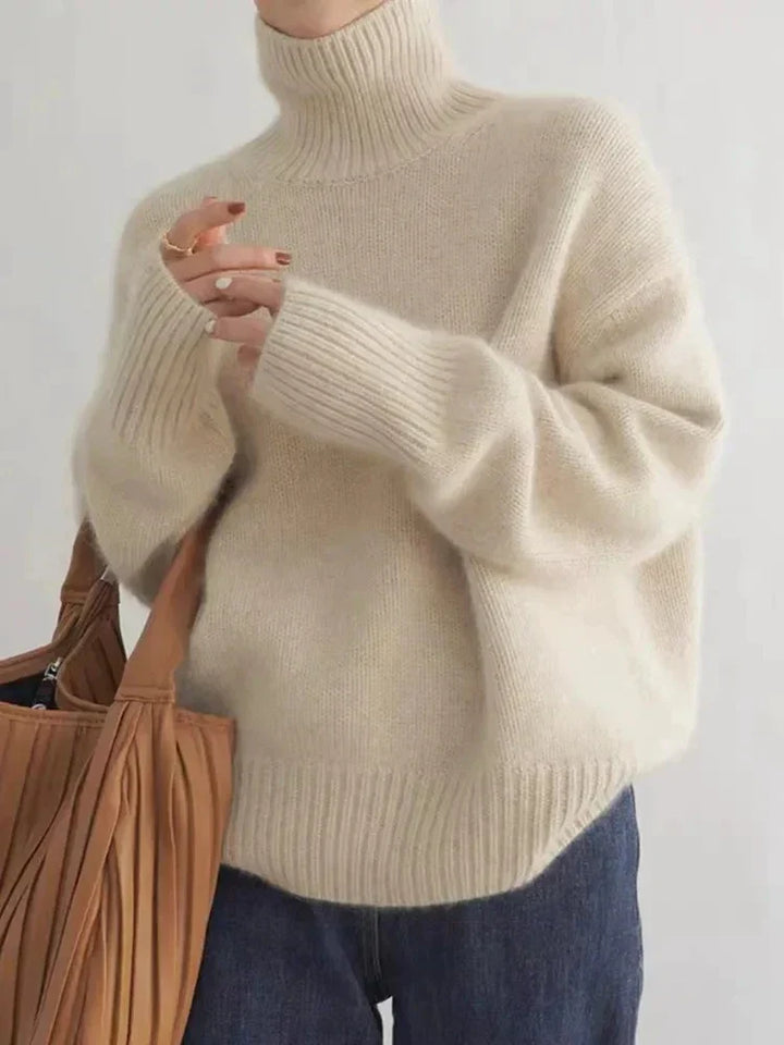 Elena oversized turtleneck sweater in cream, front view with tote bag