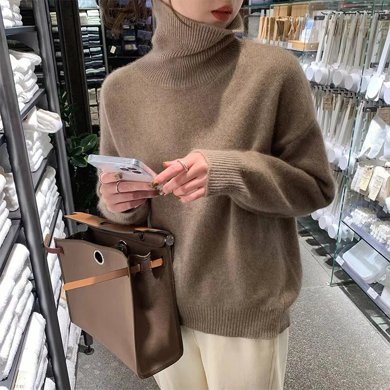 Elena turtleneck sweater in brown, front view holding phone and bag
