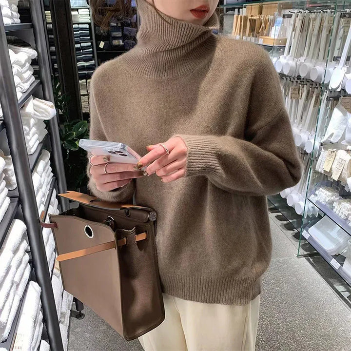 Elena turtleneck sweater in brown, front view holding phone and bag