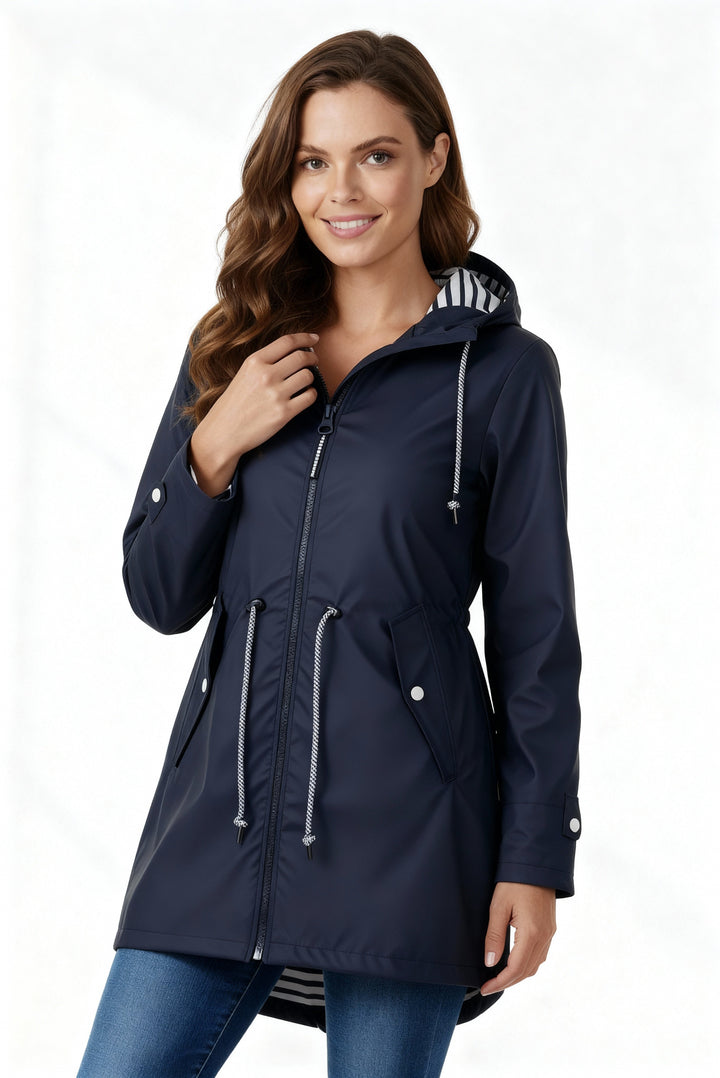 Everly navy rain jacket unzipped, model adjusting hood drawstring