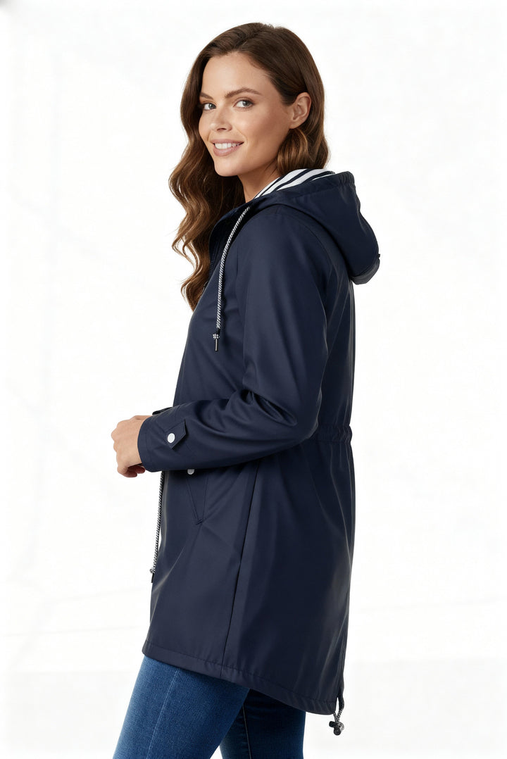Everly navy rain jacket side angle with hands in front pockets