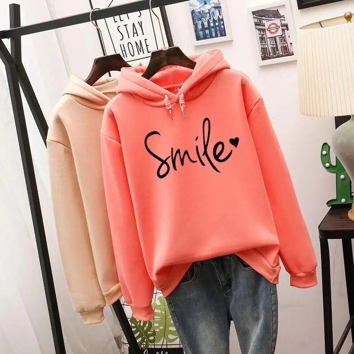Harlow oversized Smile graphic hoodie in coral, hanging with color options