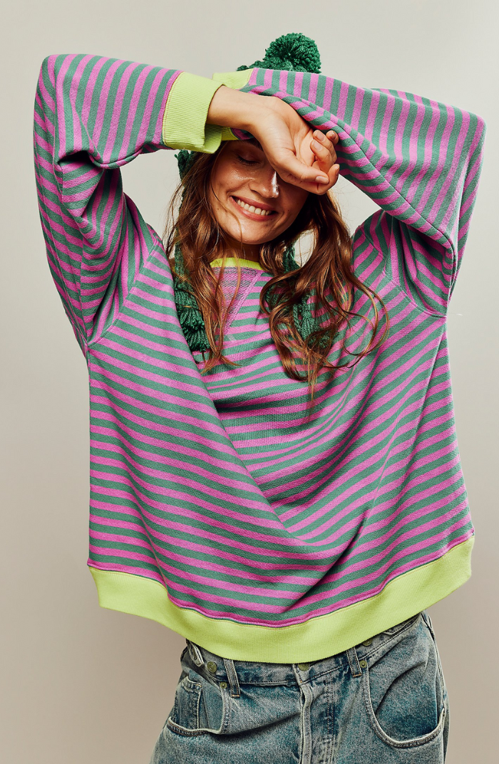 Harlow striped oversized sweatshirt in green and pink, front view with model raising arms