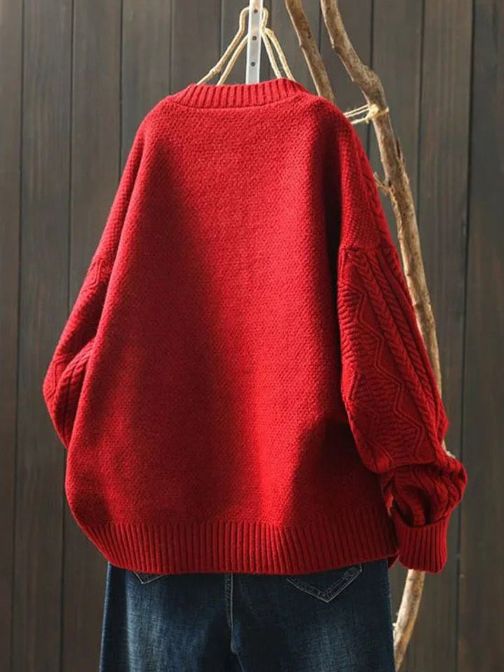Josephine oversized cable knit cardigan in red, back view on hanger