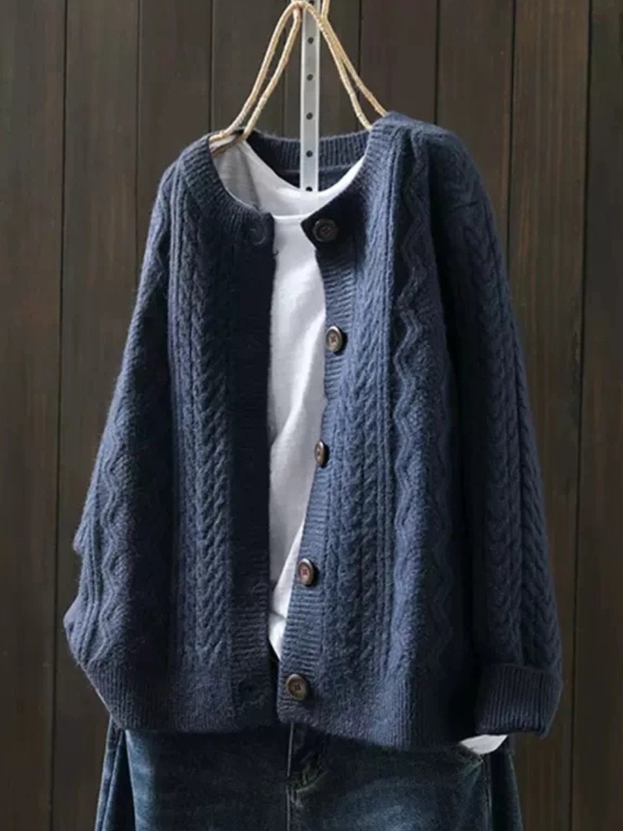 Josephine oversized cable knit cardigan in navy blue, front view on hanger