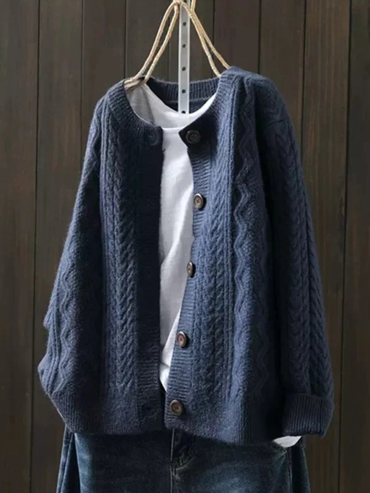 Josephine oversized cable knit cardigan in navy blue, front view on hanger