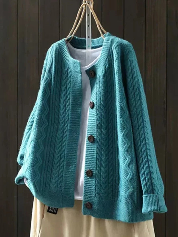 Josephine oversized cable knit cardigan in teal, front view on hanger