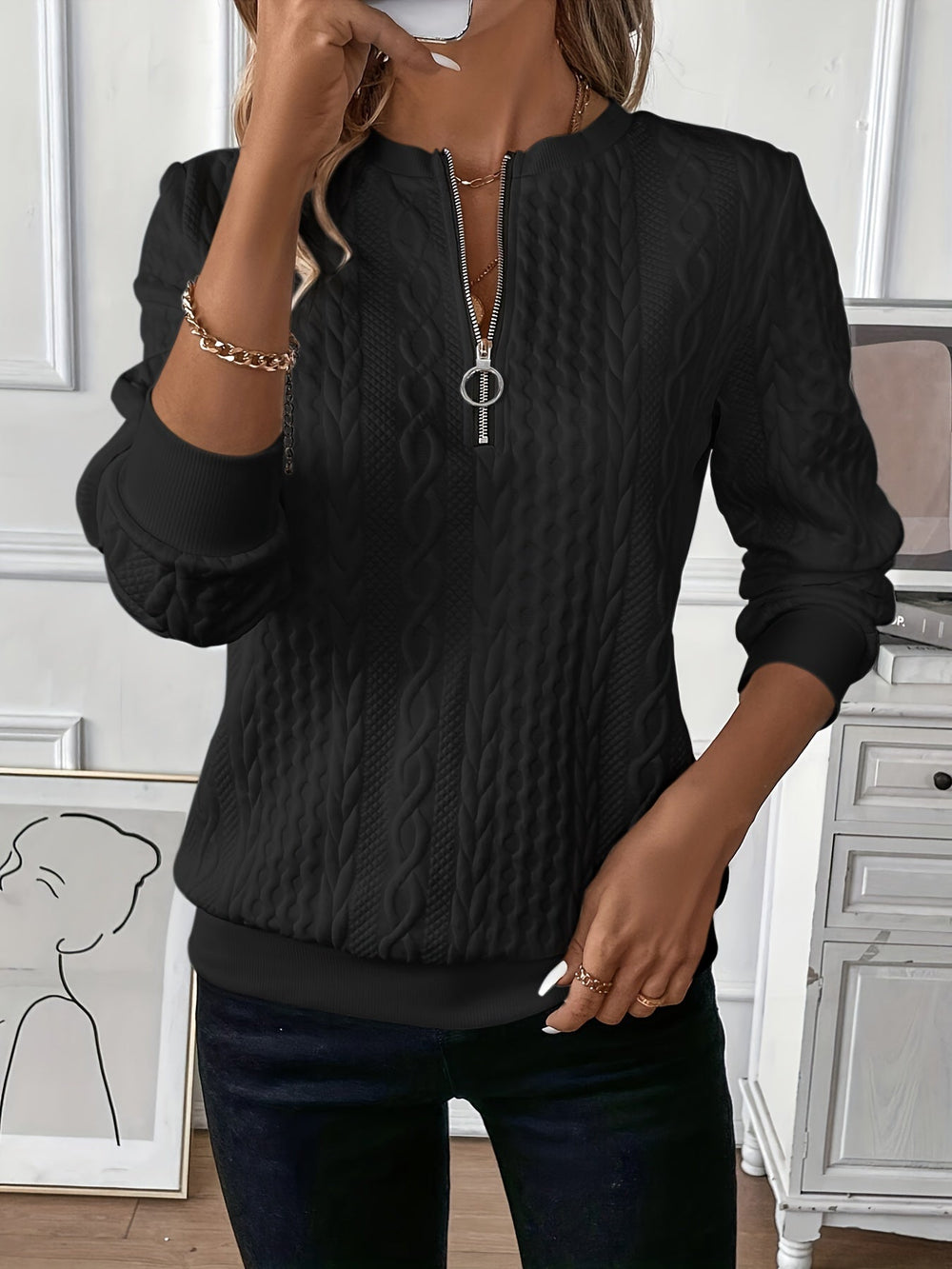 Black cable knit quarter-zip sweater, close-up front view