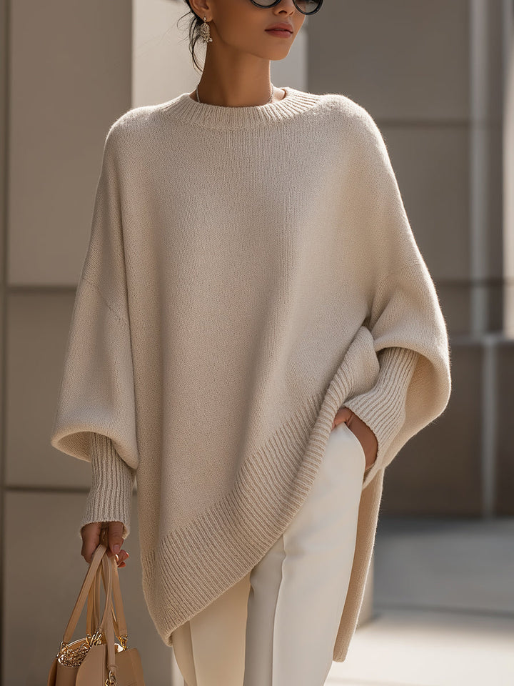 Marlowe oversized asymmetrical poncho sweater in beige, front view with hand in pocket