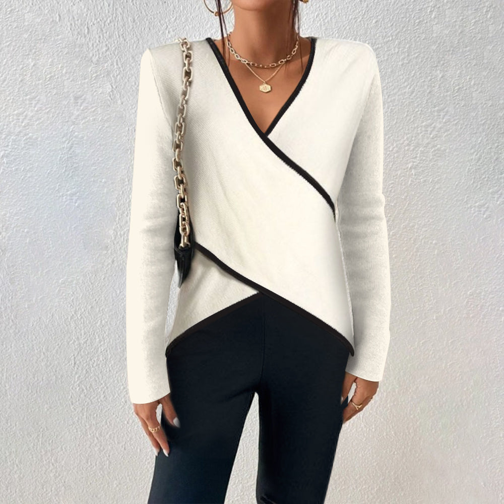 Front view of Naya asymmetric wrap V-neck sweater with black contrast trim, styled with layered necklaces and chain bag