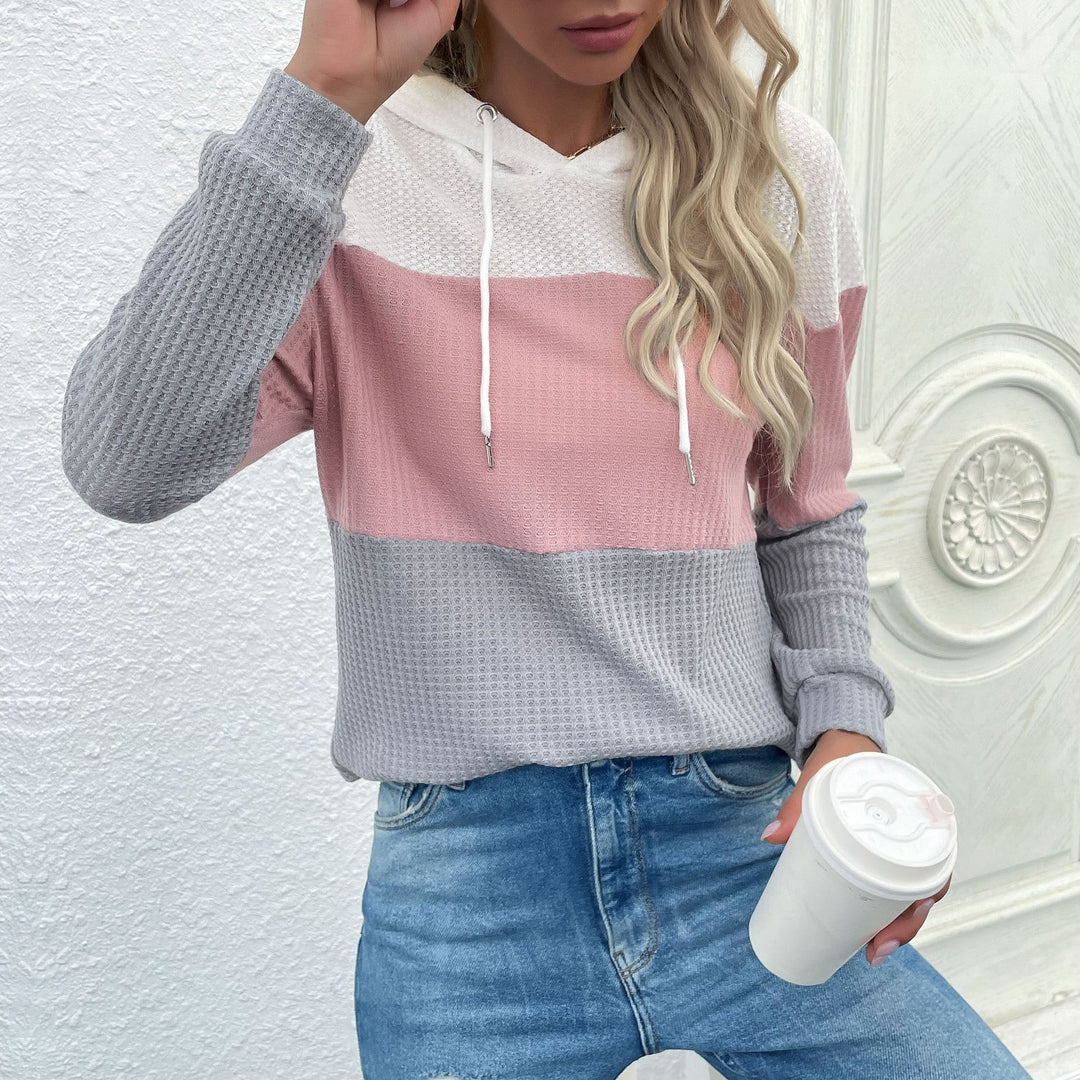 Sienna color block hoodie detail, model holding coffee cup