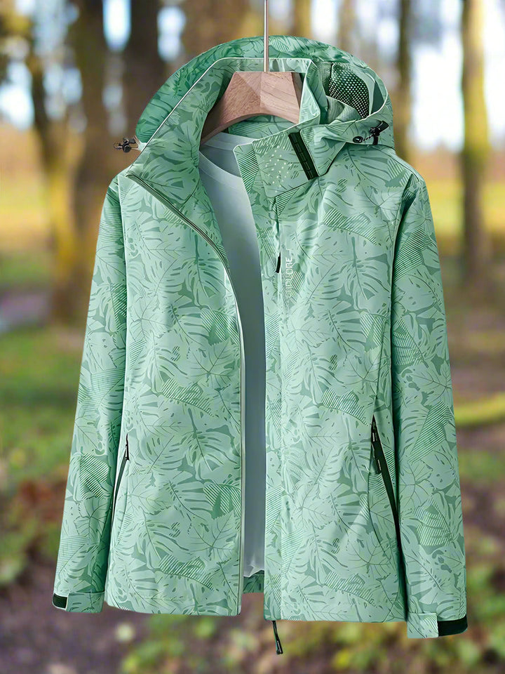 Thea hooded rain jacket in green leaf print, front view on hanger