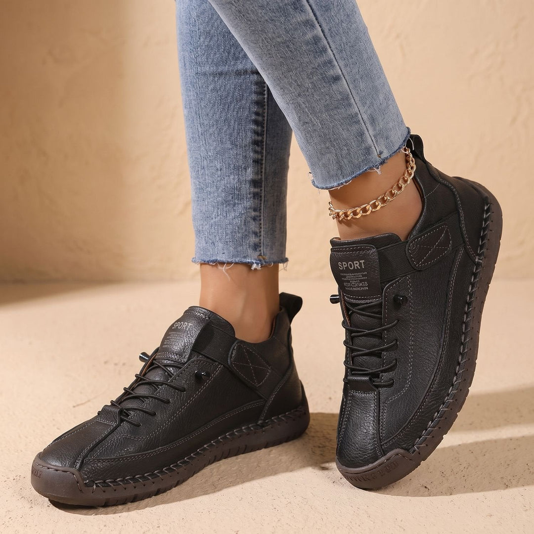 Faye black low-top sneakers worn on feet, side profile walking shot