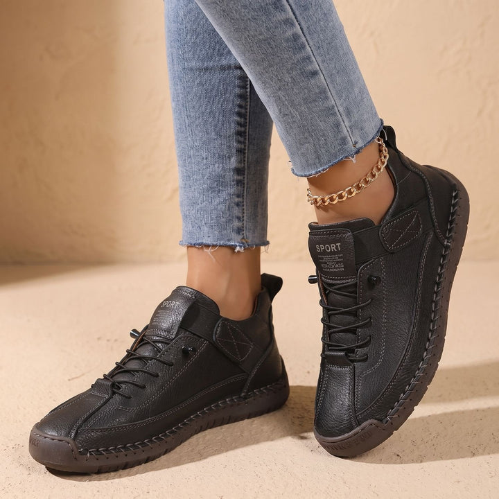 Faye black low-top sneakers worn on feet, side profile walking shot
