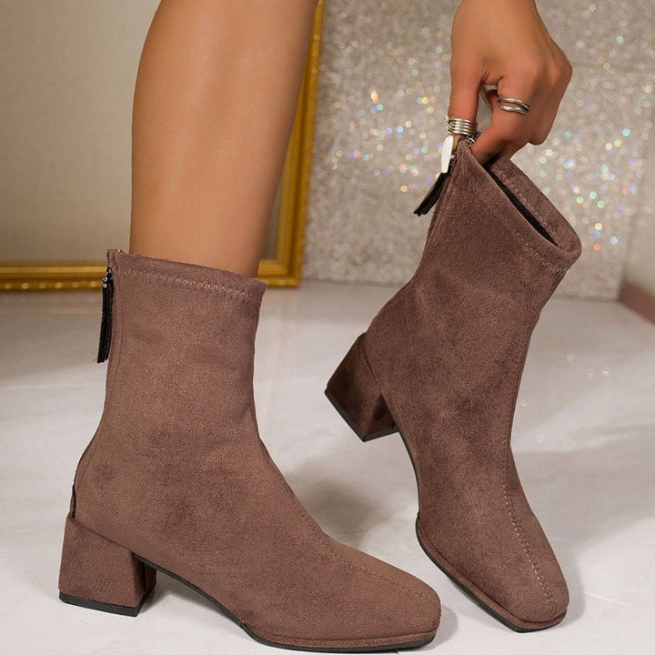 Marigold ankle boots in brown, side view being put on