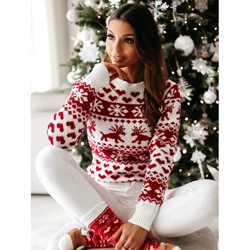 Marigold Christmas sweater worn seated near holiday decor, front view