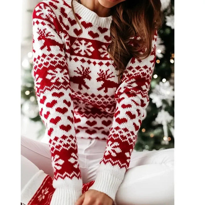 Marigold Christmas sweater worn seated near holiday decor, front view