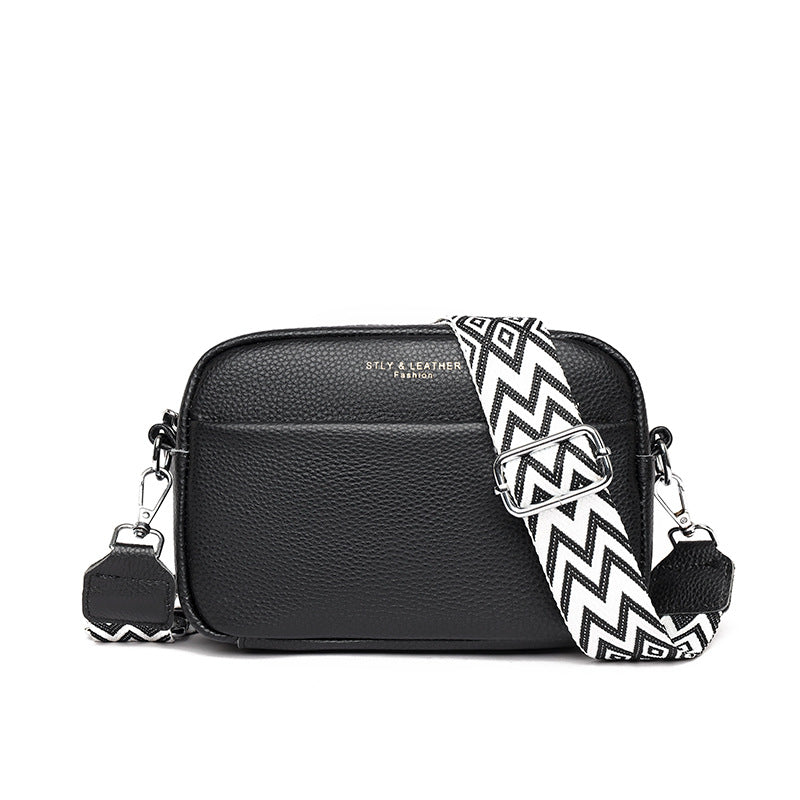 Rosalind crossbody bag in cream held in hand with patterned strap detail