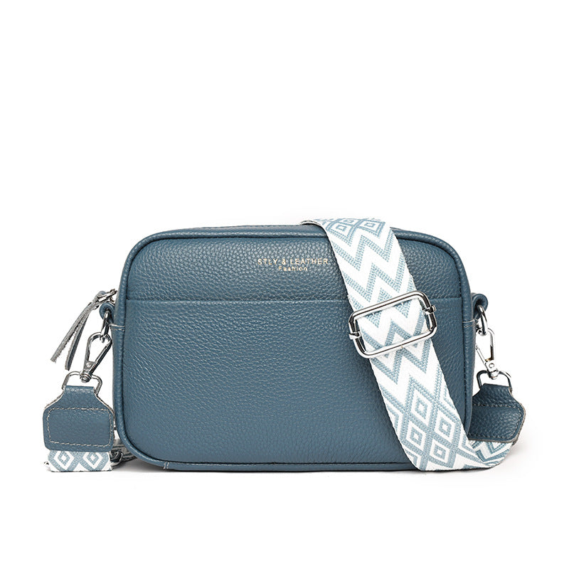 Rosalind crossbody bag in cream held in hand with patterned strap detail