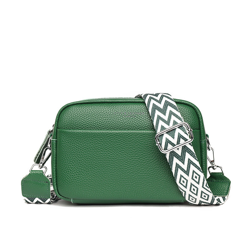 Rosalind crossbody bag in cream held in hand with patterned strap detail