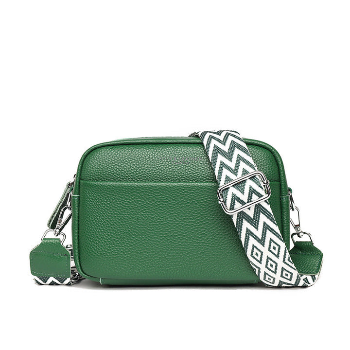 Rosalind crossbody bag in cream held in hand with patterned strap detail