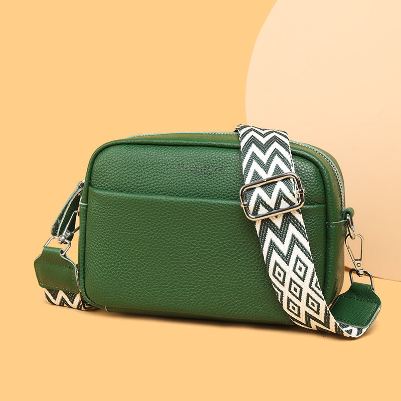 Rosalind crossbody bag in cream held in hand with patterned strap detail