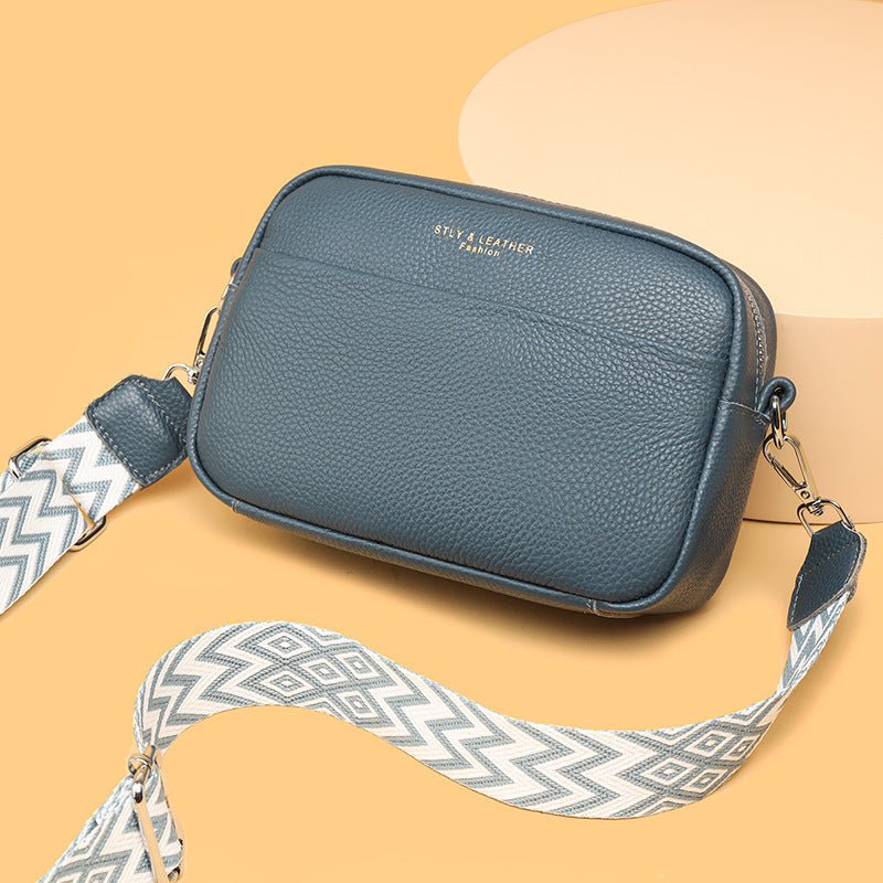 Rosalind crossbody bag in cream held in hand with patterned strap detail