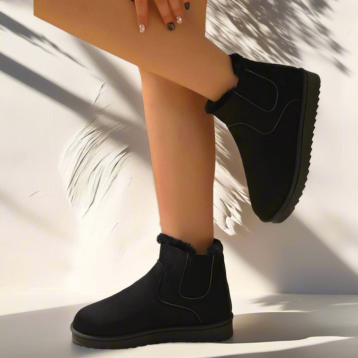 Marlowe faux fur lined Chelsea ankle boots in black, side view on model