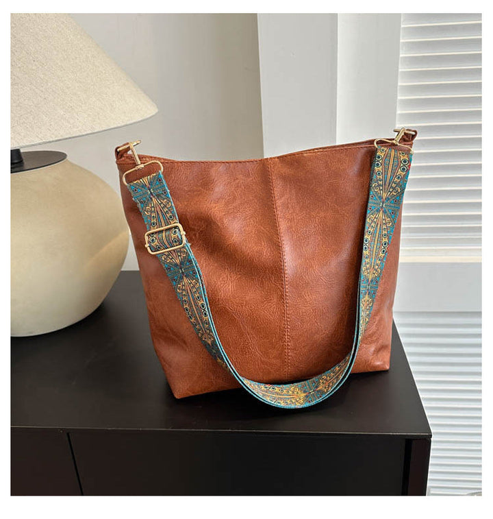 Odalys brown shoulder tote with patterned strap, front view on nightstand