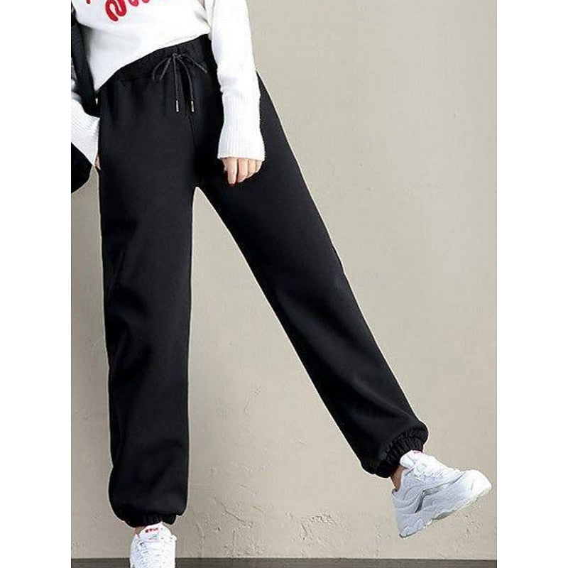 Marisol fleece lined sweatpants in black, side view with sneakers