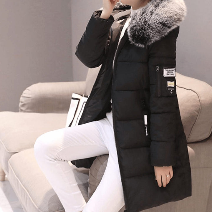 Thessaline hooded puffer jacket with pink faux fur collar, seated side view