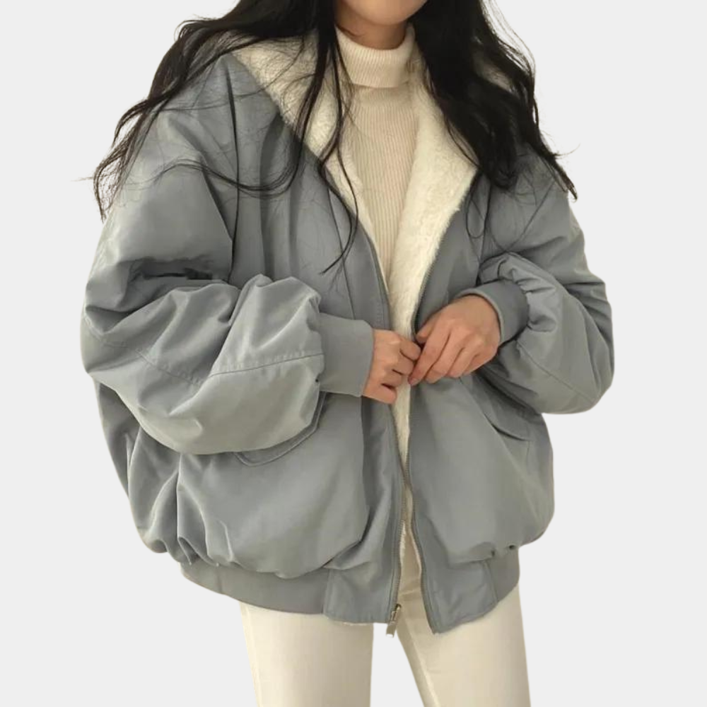 Noelani hooded oversized winter jacket in blue-gray, front view with hands on zipper
