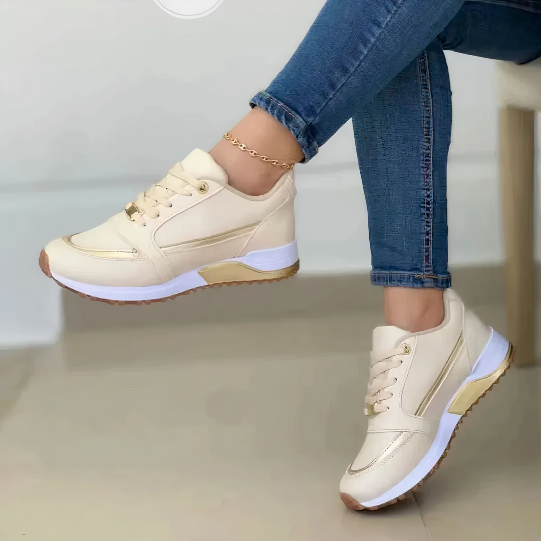 Annalise beige lace-up sneakers with gold trim, side view on model