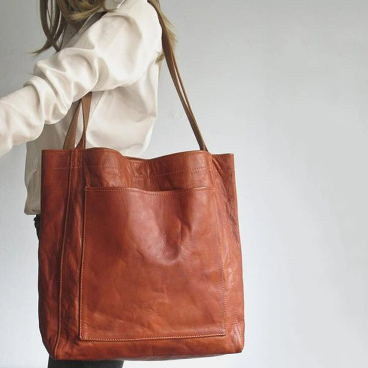 Marisabel leather tote bag with front pocket, worn on shoulder, side view