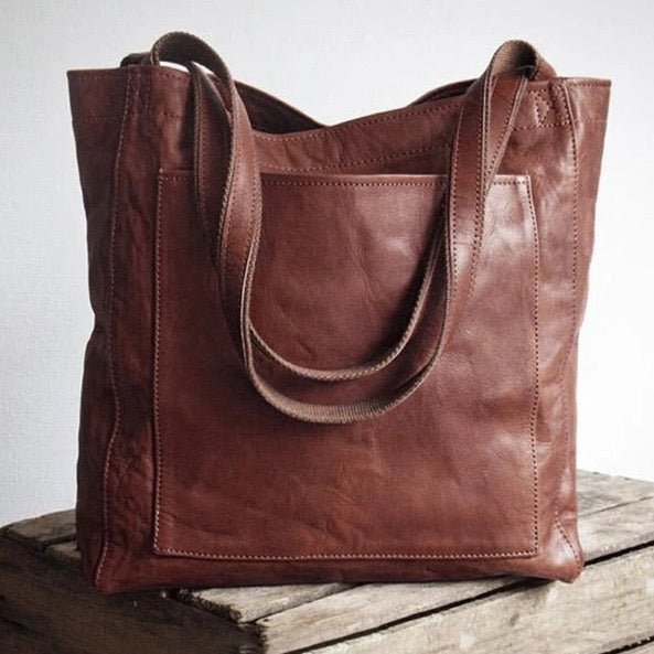 Marisabel leather tote bag front pocket detail, close-up on wooden crate