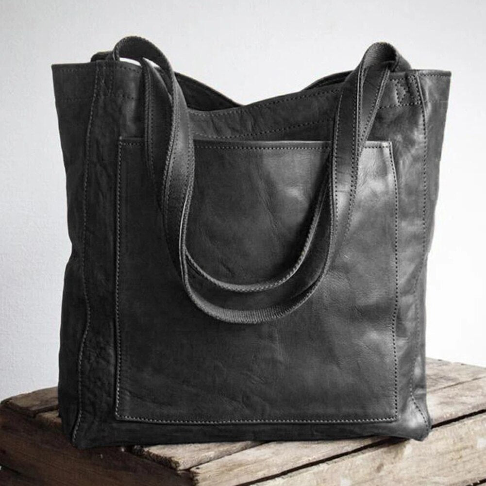 Marisabel leather tote bag in dark shade, front pocket and straps detail