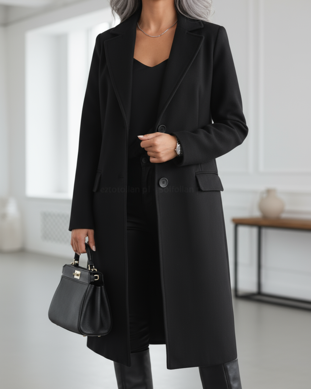 Marguerite black longline coat, front view with handbag