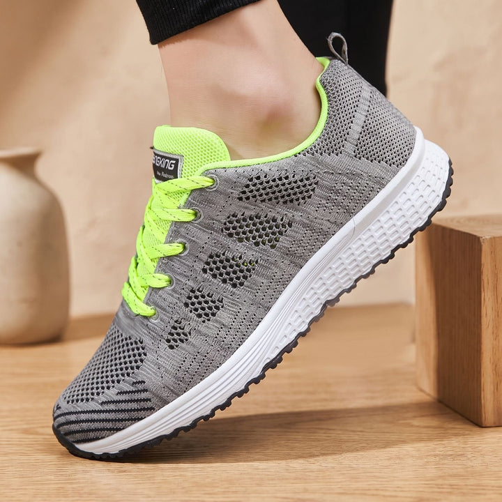 White lace-up mesh sneakers close-up showing cushioned sole and textured upper