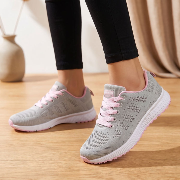 White lace-up mesh sneakers close-up showing cushioned sole and textured upper