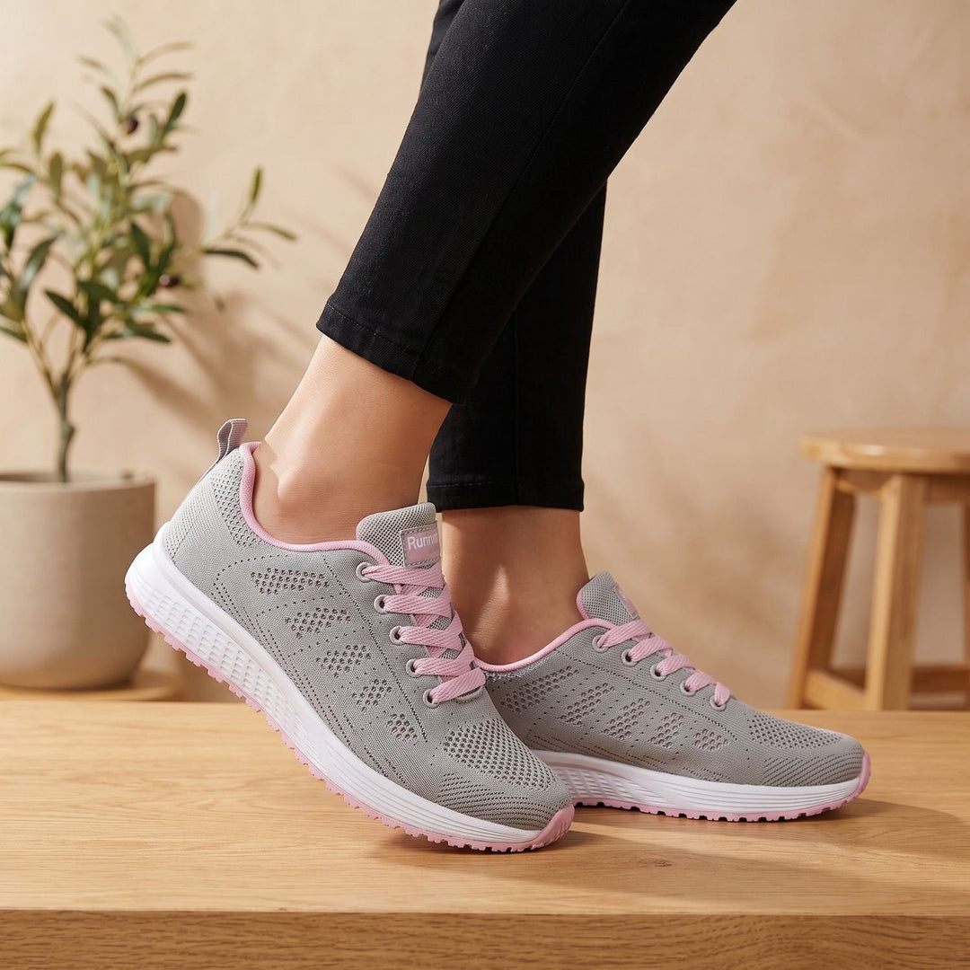 White lace-up mesh sneakers close-up showing cushioned sole and textured upper