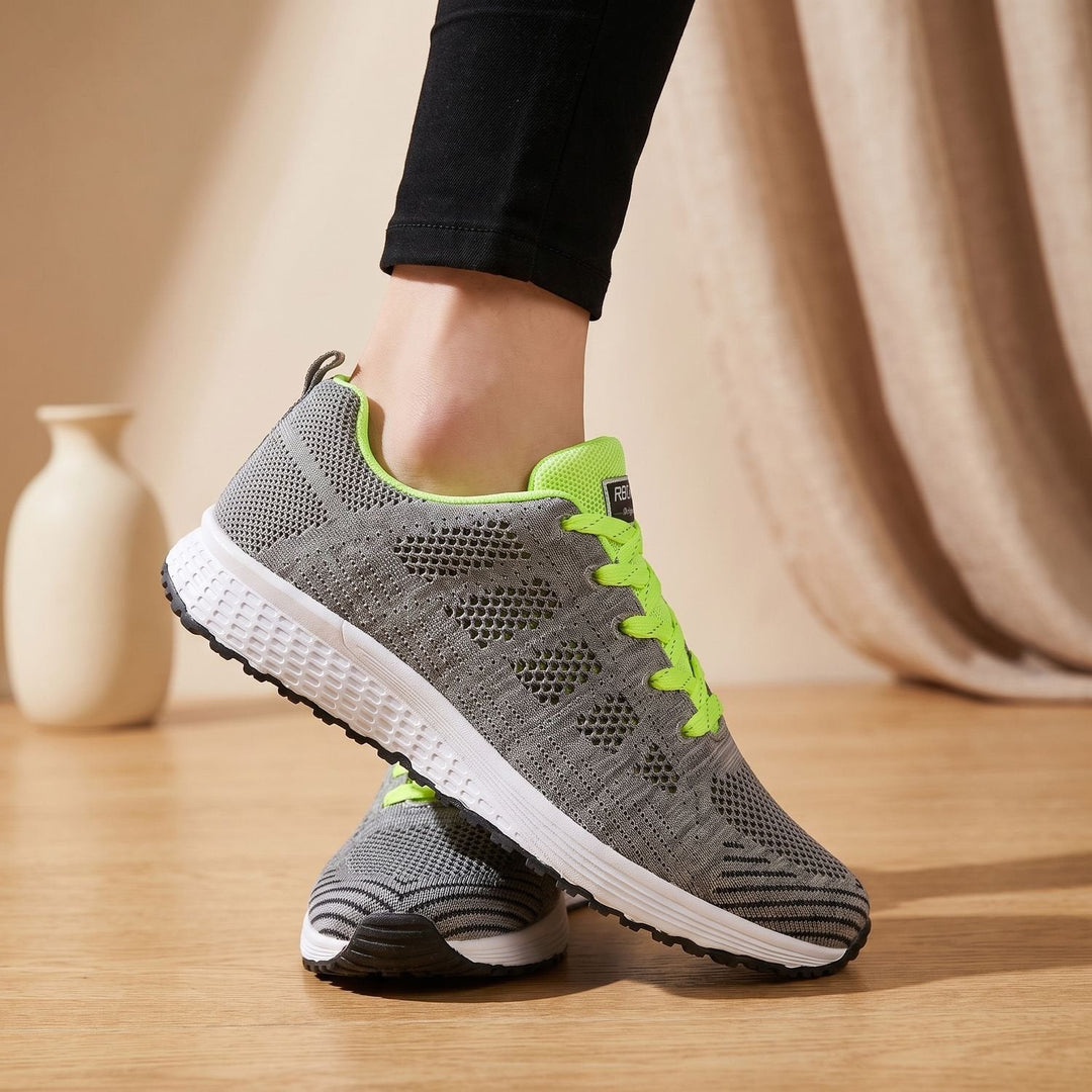 White lace-up mesh sneakers close-up showing cushioned sole and textured upper