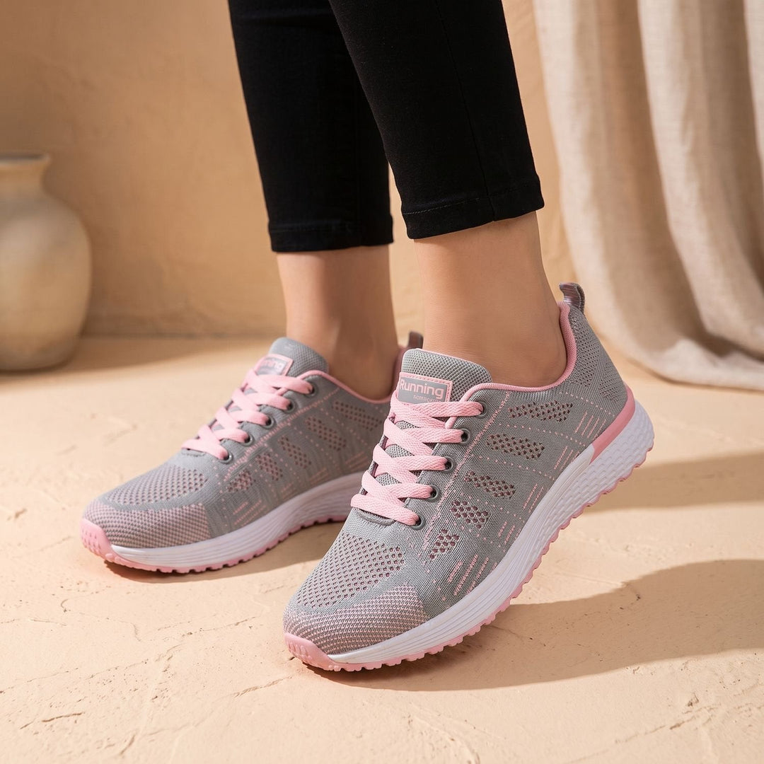 White lace-up mesh sneakers close-up showing cushioned sole and textured upper