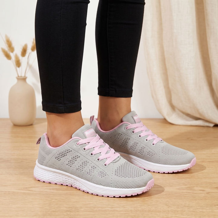 White lace-up mesh sneakers close-up showing cushioned sole and textured upper