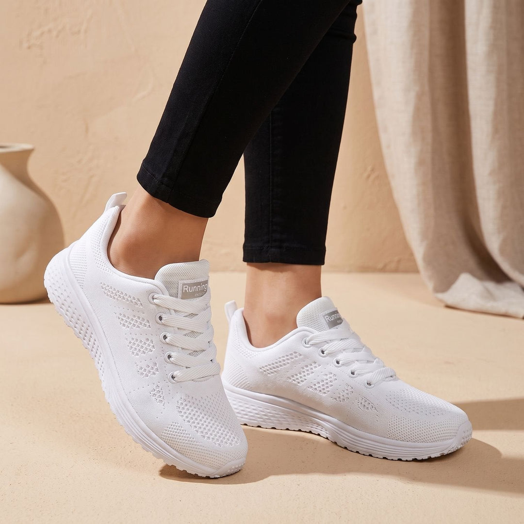 White mesh sneakers side profile with lace-up closure on model&