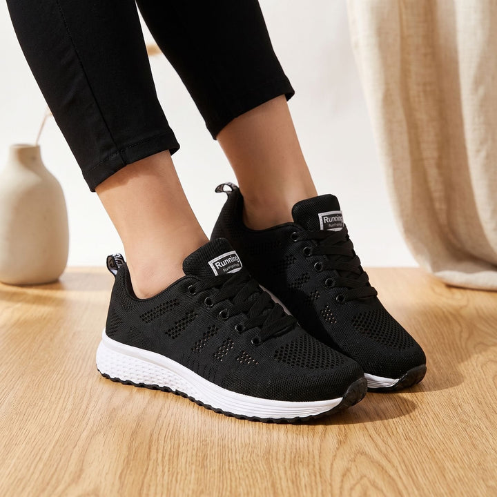 White lace-up mesh sneakers close-up showing cushioned sole and textured upper