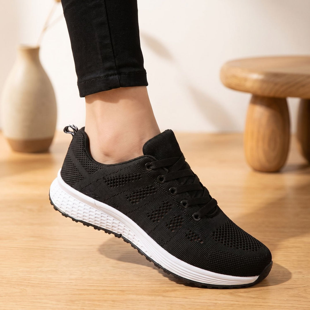 White lace-up mesh sneakers close-up showing cushioned sole and textured upper